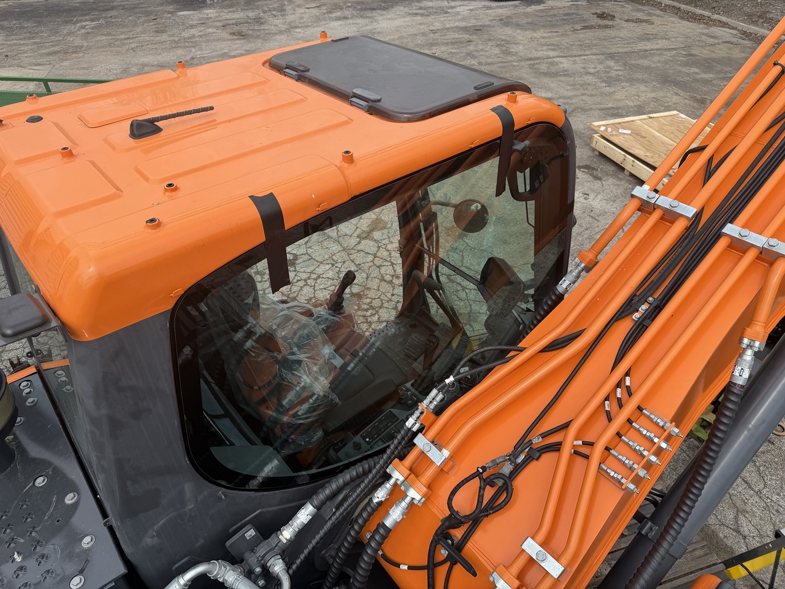 Overhead view of an orange heavy equipment cab and windshield