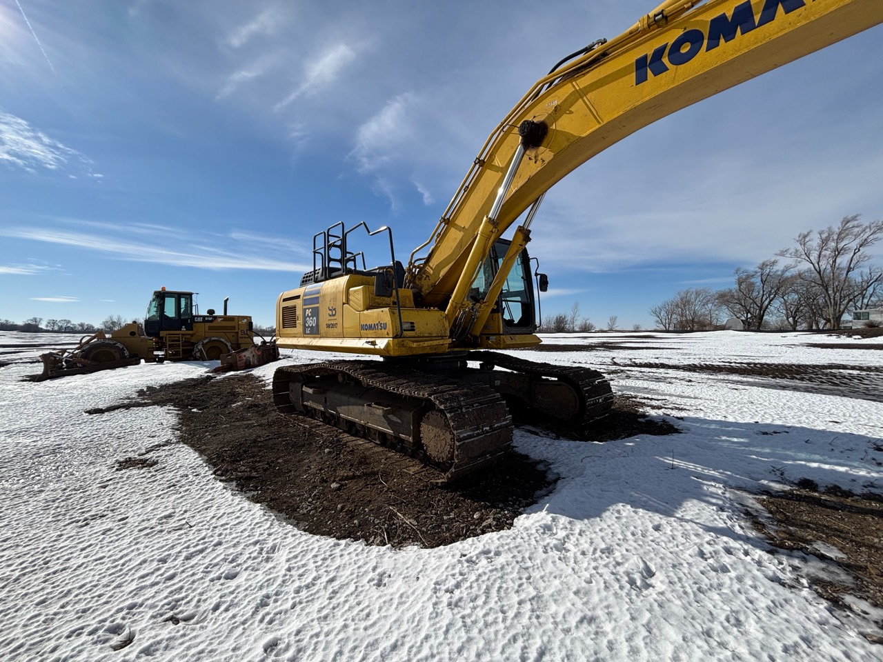 Komatsu excavator parked at a snow-covered job site