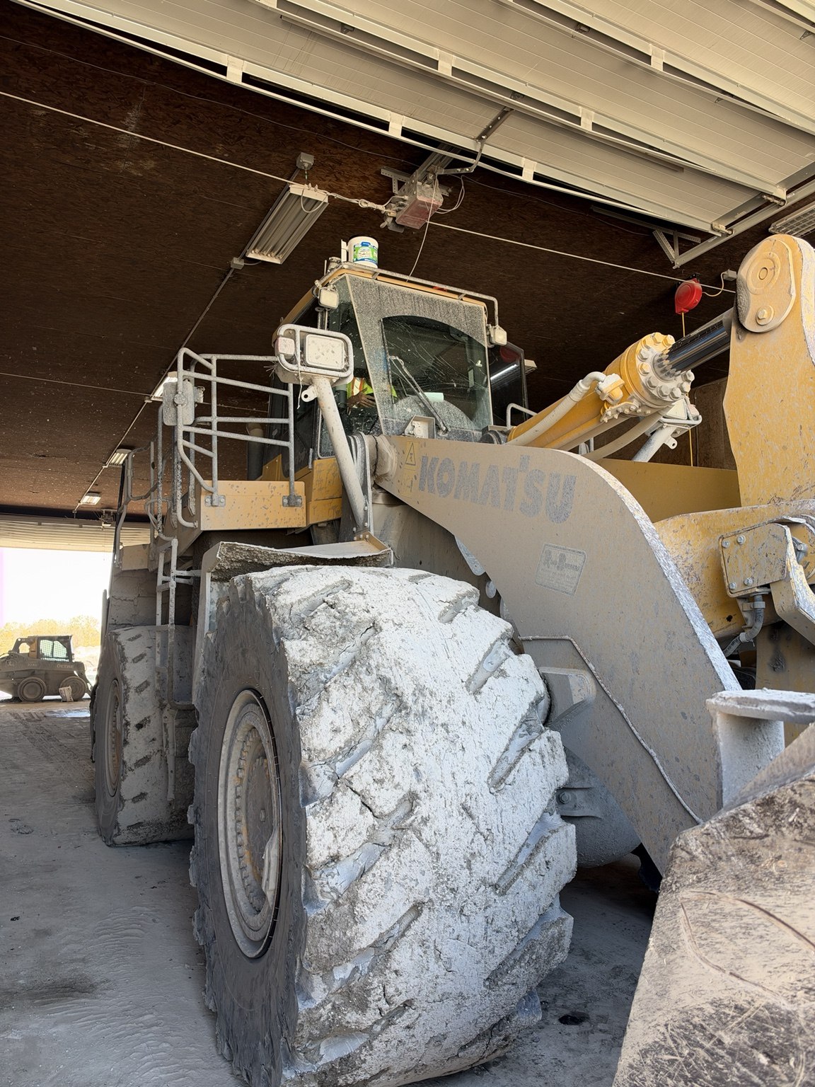 Cracked front center windshield on a Komatsu WA600 wheel loader before replacement